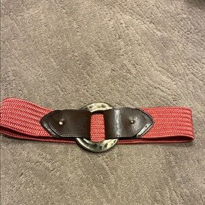 Stretchy rose colored belt with leather and large pounded silver toned circle